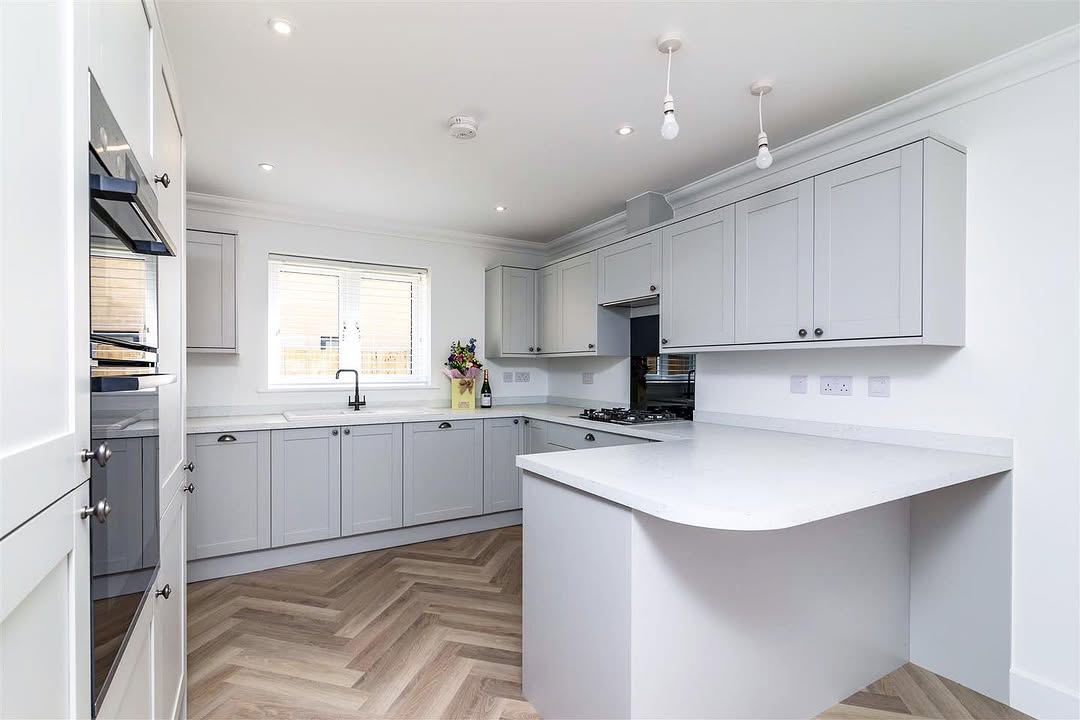 Modern kitchen interior with grey shaker cabinets and herringbone floor